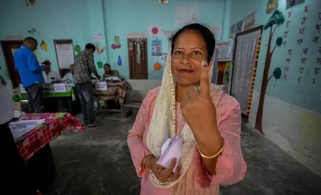 A woman shows the indelible ink mark on her finger after casting vote during the first round of polling of India's national election in Bahona village, Jorhat, northeastern Assam, India, Friday, April 19, 2024. Nearly 970 million voters will elect 543 members for the lower house of Parliament for five years, during staggered elections that will run until June 1. (AP Photo/Anupam Nath)