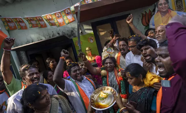 Supporters shout slogans as Bharatiya Janata Party (BJP) candidate Tamilisai Soundararajan, center, brandishes a sword presented to her during an election campaign rally ahead of country's general elections, in the southern Indian city of Chennai, April 14, 2024. (AP Photo/Altaf Qadri)
