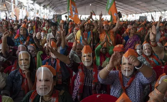 Bharatiya Janata Party (BJP) supporters wear masks of Indian Prime Minister Narendra Modi during an election rally addressed by Modi in Meerut, India, Sunday, March 31, 2024. (AP Photo/Altaf Qadri)