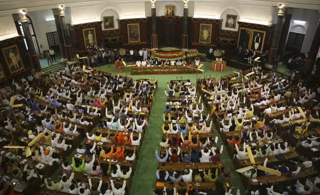 FILE- Newly elected lawmakers from India's ruling alliance led by the Hindu nationalist Bharatiya Janata Party raise their hands in support of Narendra Modi being elected their leader in New Delhi, India, May 25, 2019. India's 6-week-long general elections begin on April 19, 2024, and results will be announced on June 4. The voters, who comprise over 10% of the world's population, will elect 543 members for the lower house of Parliament for a term of five years. (AP Photo/Manish Swarup, File)