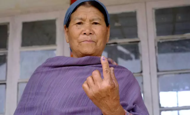 An elderly Angami Naga woman displays the indelible ink mark on her finger after casting her vote in Chedema village, in the northeastern Indian state of Nagaland, Friday, April 19, 2024. (AP Photo/Yirmiyan Arthur)