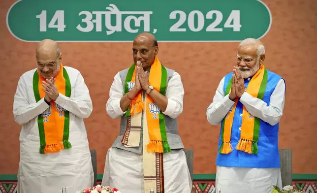 Indian Prime Minister Narendra Modi, right, stands with senior Bharatiya Janata Party (BJP) leaders, Home Minister Amit Shah, Defence Minister Rajnath Singh, center, at an event in which he released BJP's manifesto for the upcoming national parliamentary elections in New Delhi, India, Sunday, April 14, 2024.(AP Photo/Manish Swarup)