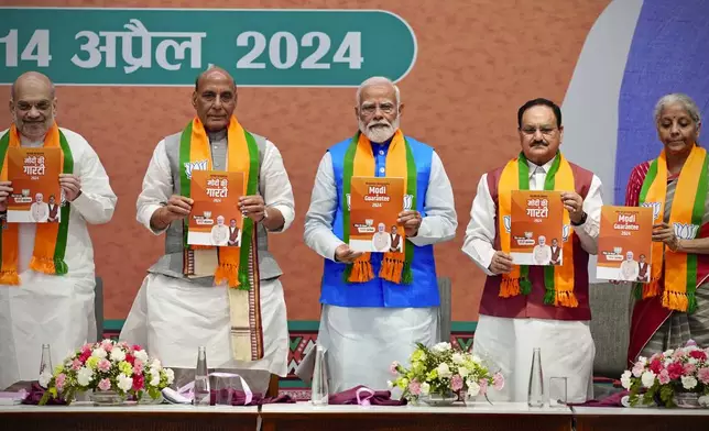 Indian Prime Minister Narendra Modi, center, releases his ruling Bharatiya Janata Party's manifesto for the upcoming national parliamentary elections in New Delhi, India, Sunday, April 14, 2024. Standing from L to R with him are BJP's senior leaders Home Minister Amit Shah, Defence Minister Rajnath Singh and Party President JP Nadda, and Finance Minister Nirmala Sitharaman. (AP Photo/Manish Swarup)