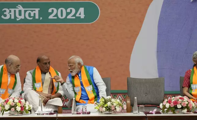 Indian prime Minister Narendra Modi, second right, talks to Bharatiya Janata Party (BJP) senior leaders and cabinet colleagues Home Minister Amit Shah, left, and Defence Minister Rajnath Singh as Finance Minister Nirmala Sitharaman, right, listens to a speaker at an event organized to release their party's manifesto for the upcoming national parliamentary elections in New Delhi, India, Sunday, April 14, 2024. Modi vowed to boost social spending, develop world-class infrastructure, and make India a global manufacturing hub as he unveiled his Hindu nationalist party's election manifesto on Sunday. (AP Photo/Manish Swarup)