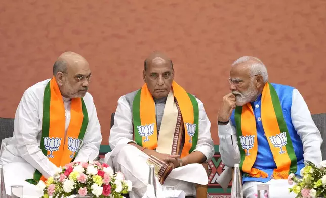 Indian prime Minister Narendra Modi, right, talks to Bharatiya Janata Party (BJP) senior leaders and his cabinet colleagues Home Minister Amit Shah, left, and Defence Minister Rajnath Singh during an event organized to release their party's manifesto for the upcoming national parliamentary elections in New Delhi, India, Sunday, April 14, 2024. Modi vowed to boost social spending, develop world-class infrastructure, and make India a global manufacturing hub as he unveiled his Hindu nationalist party's election manifesto on Sunday. (AP Photo/Manish Swarup)
