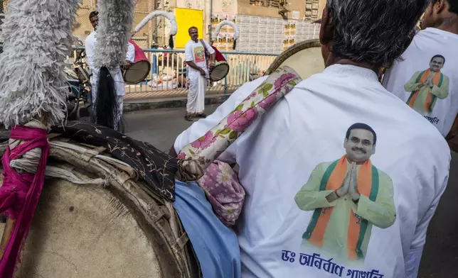 Drummers wearing shirts printed with a portrait of the local Bharatiya Janata Party (BJP) candidate Anirban Ganguly wait to play during an election rally for the forthcoming national parliamentary election in Kolkata, India, Sunday, April 14, 2024. (AP Photo/Bikas Das)
