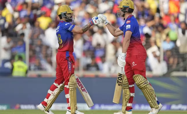 Royal Challengers Bengaluru's Virat Kohli, left, and teammate Will Jacks touch gloves during the Indian Premier League cricket match between Gujarat Titans and Royal Challengers Bengaluru in Ahmedabad, India, Sunday, April 28, 2024. (AP Photo /Ajit Solanki)