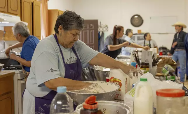 Carol Tiger, a member of Muscogee Nation and an elder at the Springfield United Methodist Church in Okemah, Okla.,, mixes dough to make frybread at the church's annual wild onion dinner on April 5, 2024. Frybread is a staple dish at wild onion dinners, which are common among tribal nations from the southeastern U.S. (AP Photo/Brittany Bendabout)