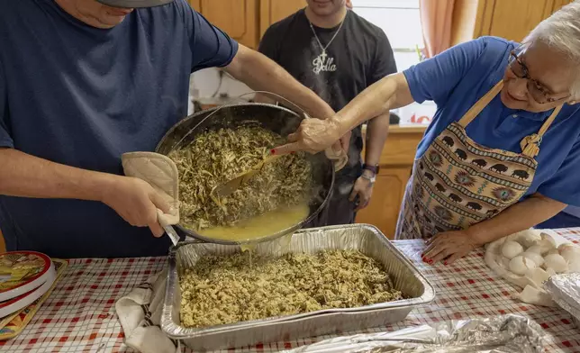 Members of the Springfield United Methodist Church in Okemah, Okla., dump a freshly cooked pot of wild onions into a tray to be served on April 6, 2024. Hundreds of people line up every year to eat at the church's annual wild onion dinner, which it uses to raise funds. (AP Photo/Brittany Bendabout)