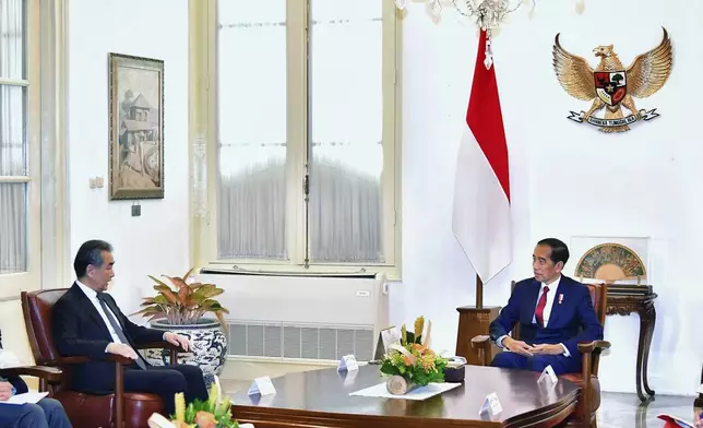 In this photo provided by the Indonesian Presidential Palace, Chinese Foreign Minister Wang Yi, left, talks with Indonesia President Joko Widodo during a meeting at the palace in Jakarta, Indonesia, Thursday, April 18, 2024. The Chinese and Indonesian foreign ministers called for an immediate and lasting cease-fire in Gaza after a meeting in Jakarta on Thursday, condemning the humanitarian costs of Israel's ongoing war against Hamas. (Vico/Indonesian Presidential Palace via AP)
