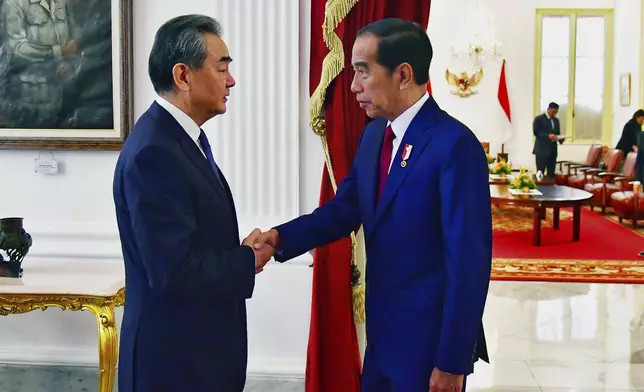 In this photo provided by the Indonesian Presidential Palace, Chinese Foreign Minister Wang Yi , left, shakes hands with Indonesia President Joko Widodo during a meeting at the palace in Jakarta, Indonesia, Thursday, April 18, 2024. The Chinese and Indonesian foreign ministers called for an immediate and lasting cease-fire in Gaza after a meeting in Jakarta on Thursday, condemning the humanitarian costs of Israel's ongoing war against Hamas. (Vico/Indonesian Presidential Palace via AP)