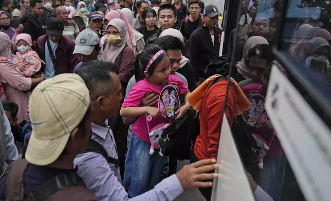 People board a bus as they leave for their hometown ahead of the Eid al-Fitr holiday at Kalideres Bus Terminal in Jakarta, Indonesia, Saturday, April 6, 2024. Millions of Indonesians are packing bus and train stations, airports and highways as they head to hometowns to celebrate Thursday's Eid al-Fitr festival with family. (AP Photo/Dita Alangkara)