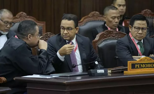 Presidential candidate Anies Baswedan, center, and his running mate Muhaimin Iskandar, right, confer with their lawyer Ari yusuf Amir during their election appeal hearing at the Constitutional Court in Jakarta, Indonesia, Monday, April 22, 2024. The country's top court on Monday rejected appeals lodged by two losing presidential candidates who are demanding a revote, alleging widespread irregularities and fraud at the February polls. (AP Photo/Dita Alangkara)