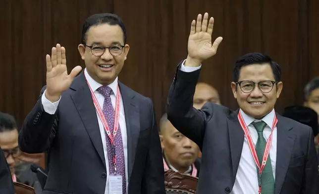 Presidential candidate Anies Baswedan, left, and his running mate Muhaimin Iskandar wave at the media upon arrival for their election appeal hearing at the Constitutional Court in Jakarta, Indonesia, Monday, April 22, 2024. The country's top court on Monday rejected appeals lodged by two losing presidential candidates who are demanding a revote, alleging widespread irregularities and fraud at the February polls. (AP Photo/Dita Alangkara)