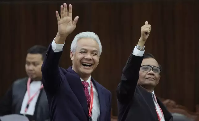 Presidential candidate Ganjar Pranowo, left, and his running mate Mahfud MD wave at the media upon arrival for their election appeal hearing at the Constitutional Court in Jakarta, Indonesia, Monday, April 22, 2024. The country's top court on Monday rejected appeals lodged by two losing presidential candidates who are demanding a revote, alleging widespread irregularities and fraud at the February polls. (AP Photo/Dita Alangkara)