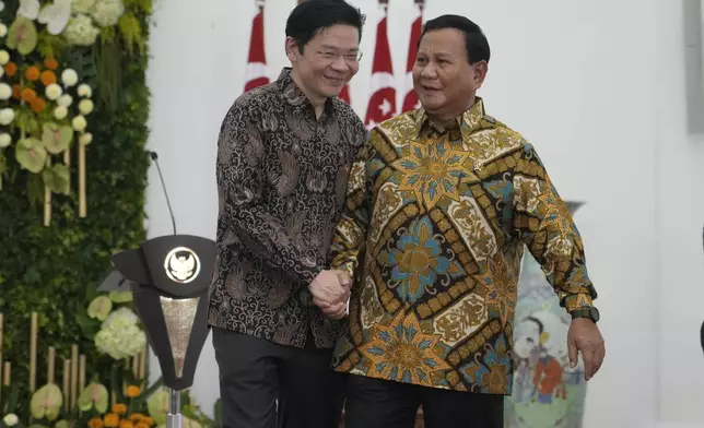 Indonesian Defense Minister and president-elect Prabowo Subianto, right, shakes hands with Singapore's Deputy Prime Minister and Finance Minister Lawrence Wong at Bogor Presidential Palace in Bogor, Indonesia, Monday, April 29, 2024. (AP Photo/Achmad Ibrahim)