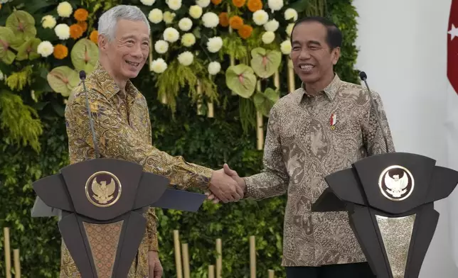 Indonesian President Joko Widodo, right, and Singapore's Prime Minister Lee Hsien Loong shake hands after a joint press conference at Bogor Presidential Palace in Bogor, Indonesia, Monday, April 29, 2024. (AP Photo/Achmad Ibrahim)(AP Photo/Achmad Ibrahim)
