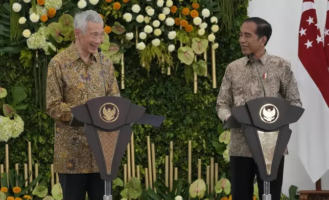 Singapore's Prime Minister Lee Hsien Loong, left, talks to journalist as Indonesian President Joko Widodo listens during a joint press conference at Bogor Presidential Palace in Bogor, Indonesia, Monday, April 29, 2024. (AP Photo/Achmad Ibrahim)