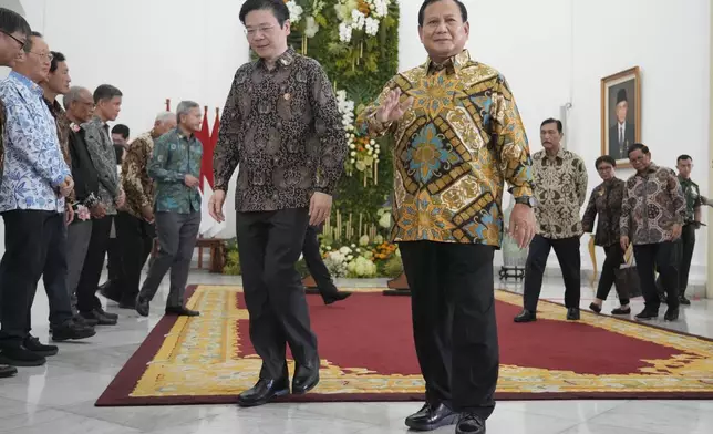 Indonesian Defense Minister and president-elect Prabowo Subianto, right, and Singapore's Deputy Prime Minister and Finance Minister Lawrence Wong walk during their meeting at Bogor Presidential Palace in Bogor, Indonesia, Monday, April 29, 2024. (AP Photo/Achmad Ibrahim)