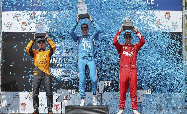 FILE - Team Penske driver Josef Newgarden, center, celebrates his first place finish along with second place finisher Arrow McLaren driver Pato O'Ward of Mexico, left, and third place finisher Team Penske driver Scott McLaughlin of New Zealand in the IndyCar Grand Prix of St. Petersburg auto race, Sunday, March 10, 2024, in St. Petersburg, Fla. Team Penske suffered a humiliating disqualification Wednesday, April 24, when reigning Indianapolis 500 winner Josef Newgarden was stripped of his victory in the season-opening race for manipulating his push-to-pass system. Penske teammate Scott McLaughlin, who finished third in the opener on the downtown streets of St. Petersburg, Florida, was also disqualified. (AP Photo/Mike Carlson, File)