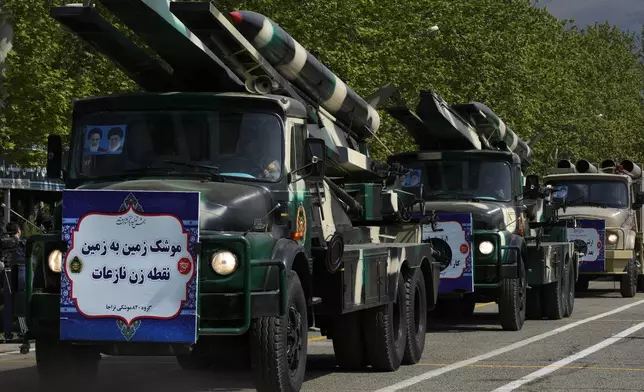 Missiles are carried on trucks during Army Day parade at a military base in northern Tehran, Iran, Wednesday, April 17, 2024. In the parade, President Ebrahim Raisi warned that the "tiniest invasion" by Israel would bring a "massive and harsh" response, as the region braces for potential Israeli retaliation after Iran's attack over the weekend. The banner on the truck reads in Farsi: "Surface-to-surface Nazeat precision missile." (AP Photo/Vahid Salemi)