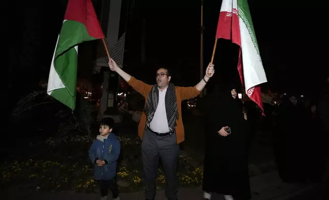A demonstrator waves Iranian and Palestinian flags during an anti-Israeli gathering at the Felestin (Palestine) Square in Tehran, Iran, early Sunday, April 14, 2024. Iran launched its first direct military attack against Israel Saturday. The Israeli military says Iran fired more than 100 bomb-carrying drones toward Israel. Hours later, Iran announced it had also launched much more destructive ballistic missiles. (AP Photo/Vahid Salemi)