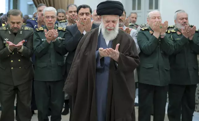 In this photo released by the official website of the office of the Iranian supreme leader, Supreme Leader Ayatollah Ali Khamenei, center, leads a prayer during his meeting with a group of senior military leaders, in Tehran, Iran, Sunday, April 21, 2024. Iran's supreme leader on Sunday dismissed any discussion of whether Tehran's unprecedented drone-and-missile attack on Israel hit anything there, a tacit acknowledgment that despite launching a massive assault, few projectiles actually made through to their targets. (Office of the Iranian Supreme Leader via AP)