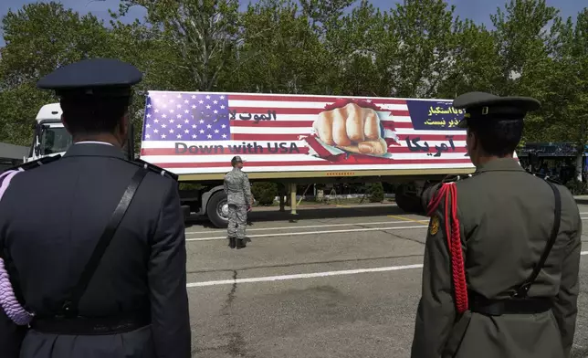 An anti-U.S. banner is carried on a truck during Army Day parade at a military base in northern Tehran, Iran, Wednesday, April 17, 2024. In the parade, President Ebrahim Raisi warned that the "tiniest invasion" by Israel would bring a "massive and harsh" response, as the region braces for potential Israeli retaliation after Iran's attack over the weekend. (AP Photo/Vahid Salemi)
