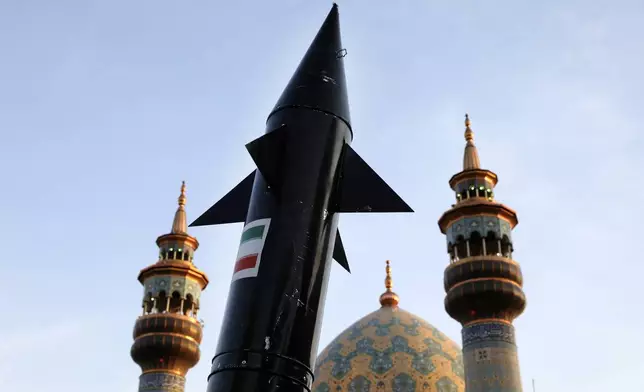 A model of a missile is carried by Iranian demonstrators as minarets and dome of a mosque is seen at background during an anti-Israeli gathering at the Felestin (Palestine) Sq. in Tehran, Iran, Monday, April 15, 2024. World leaders are urging Israel not to retaliate after Iran launched an attack involving hundreds of drones, ballistic missiles and cruise missiles. (AP Photo/Vahid Salemi)