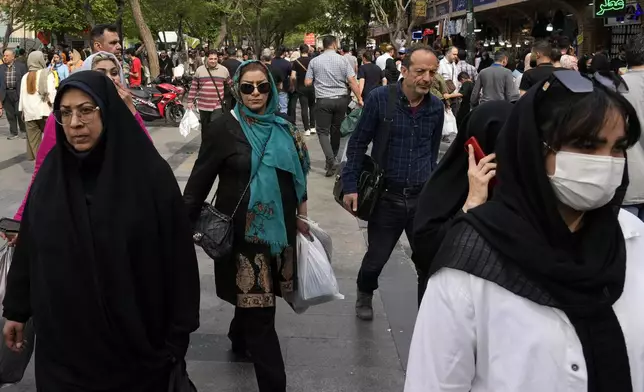 People walk around the old main bazaar in Tehran, Iran, Tuesday, April 16, 2024. Israel says it is poised to retaliate against Iran, risking further expanding the shadow war between the two foes into a direct conflict after an Iranian attack over the weekend sent hundreds of munitions into Israeli airspace. (AP Photo/Vahid Salemi)