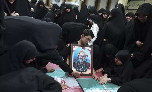 In this photo released by an official website of the office of the Iranian supreme leader, families mourn over the flag-draped coffins of the Iranian Revolutionary Guards members who were killed in an airstrike in Syria on Monday widely blamed on Israel, in Tehran, Iran, Thursday, April 4, 2024. (Office of the Iranian Supreme Leader via AP)