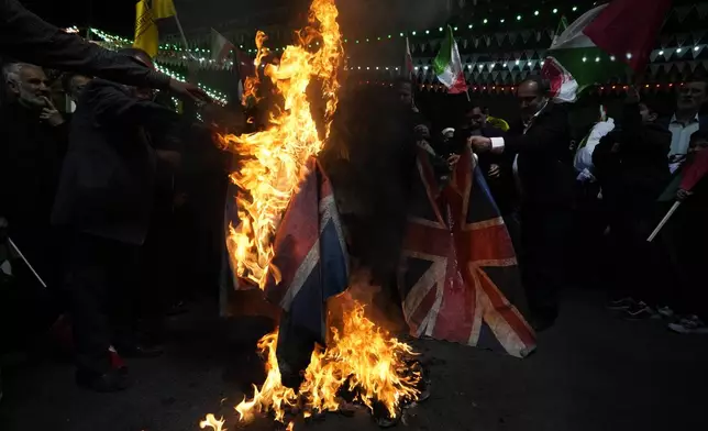 Iranian protesters burn representations of the British flag during their anti-Israeli gathering to condemn killing members of the Iranian Revolutionary Guard in Syria, at the Felestin (Palestine) Sq. in downtown Tehran, Iran, Monday, April 1, 2024. An Israeli airstrike that demolished Iran's consulate in Syria killed two Iranian generals and five officers, Syrian and Iranian officials said Monday. (AP Photo/Vahid Salemi)