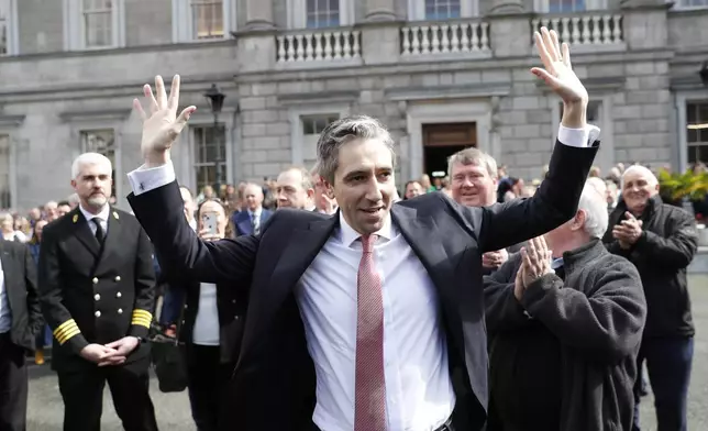 The new Prime Minister of Ireland, Simon Harris gestures as he is applauded by fellow lawmakers outside Leinster House in Dublin, Ireland, Tuesday, April 9, 2024. Harris was selected after the previous Prime Minister Leo Varadkar resigned. (AP Photo/Peter Morrison)