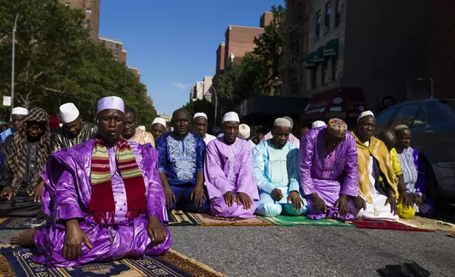 FILE - Imam Souleimane Konaté, left, leads worshippers in Eid al-Fitr prayer in New York on Sunday, June 25, 2017. (AP Photo/Michael Noble Jr., File)