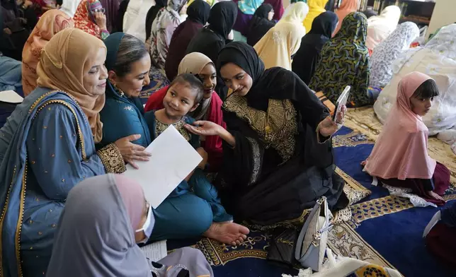 FILE - Women and children gather before Eid al-Fitr prayers, Friday, April 21, 2023, at the Muslim Community Center in Silver Spring, Md. (AP Photo/Carolyn Kaster, File)