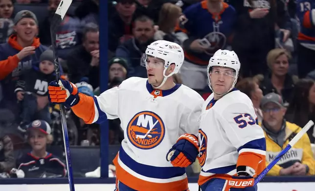 New York Islanders center Bo Horvat (14) celebrates a goal with teammate New York Islanders center Casey Cizikas (53) during the first period of an NHL hockey game against the Columbus Blue Jackets on Thursday, April 4, 2024, in Columbus, Ohio. (AP Photo/Joe Maiorana)