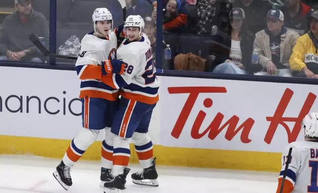 New York Islanders defenseman Noah Dobson (8) celebrates after his goal with defenseman Alexander Romanov (28) during the third period of an NHL hockey game against the Columbus Blue Jackets, Thursday, April 4, 2024, in Columbus, Ohio. (AP Photo/Joe Maiorana)