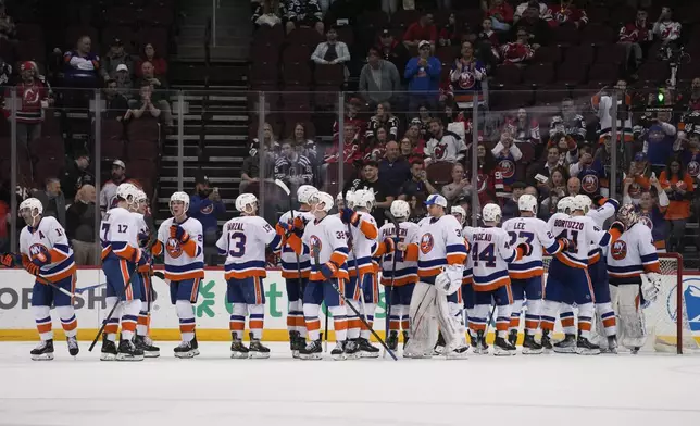 The New York Islanders celebrate after an NHL hockey game against the New Jersey Devils in Newark, N.J., Monday, April 15, 2024. (AP Photo/Seth Wenig)