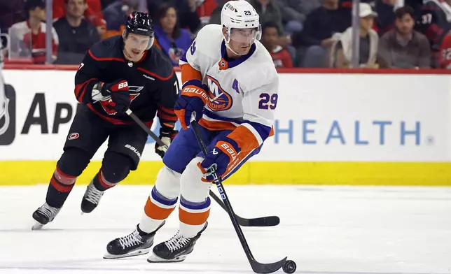 New York Islanders' Brock Nelson (29) moves the puck after taking it from Carolina Hurricanes' Dmitry Orlov (7) during the first period in Game 2 of an NHL hockey Stanley Cup first-round playoff series in Raleigh, N.C., Monday, April 22, 2024. (AP Photo/Karl B DeBlaker)