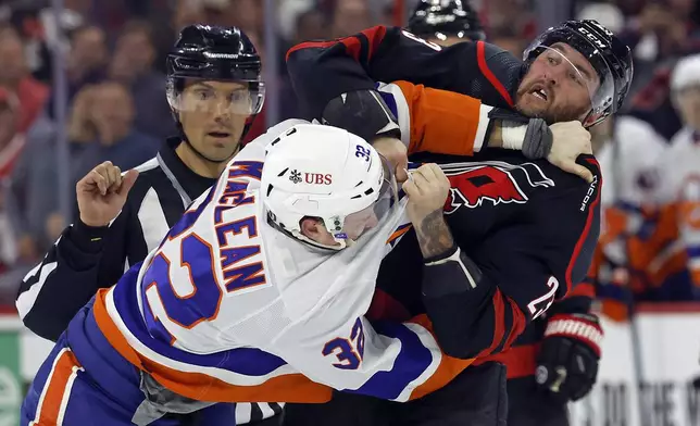 Carolina Hurricanes' Stefan Noesen (23) exchanges blows with New York Islanders' Kyle MacLean (32) during the first period in Game 2 of an NHL hockey Stanley Cup first-round playoff series in Raleigh, N.C., Monday, April 22, 2024. (AP Photo/Karl B DeBlaker)