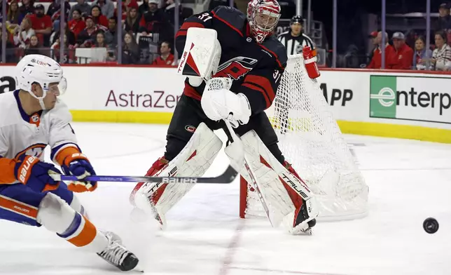 Carolina Hurricanes goaltender Frederik Andersen (31) clears the puck in front of New York Islanders' Bo Horvat (14) during the first period in Game 2 of an NHL hockey Stanley Cup first-round playoff series in Raleigh, N.C., Monday, April 22, 2024. (AP Photo/Karl B DeBlaker)