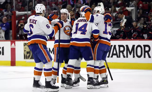 The New York Islanders celebrate a goal by Bo Horvat (14) during the first period in Game 2 of an NHL hockey Stanley Cup first-round playoff series against the Carolina Hurricanes in Raleigh, N.C., Monday, April 22, 2024. (AP Photo/Karl B DeBlaker)