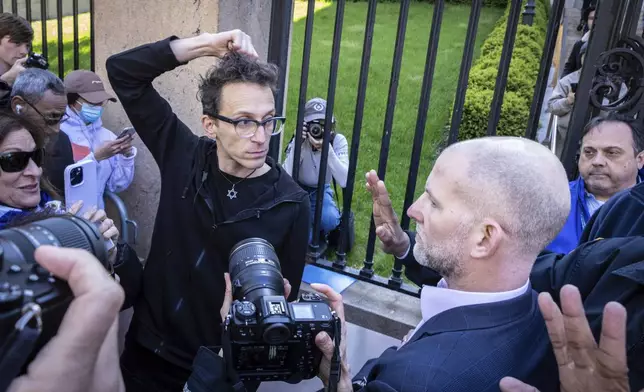 Columbia University assistant professor Shai Davidai, left, is denied access to the main campus after his security card was deactivated, to prevent him from accessing the lawn currently occupied by pro-Palestine student demonstrators in New York on Monday, April 22, 2024. (AP Photo/Stefan Jeremiah)