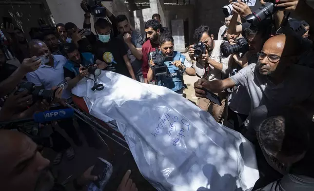 FILE - Members of the World Central Kitchen aid group, transports the body of one of the six foreign aid workers who were killed in an Israeli strike, at a hospital morgue in Rafah, Wednesday, April 3, 2024. World Central Kitchen and a few other aid groups suspended operations in Gaza, after seven aid workers were killed by airstrikes. Yet despite the danger, many of the largest organizations barely slowed down. Hunger has become commonplace in Gaza amid the war with Israel, and U.N. officials warn that famine is increasingly likely in northern Gaza. (AP Photo/Fatima Shbair, File)
