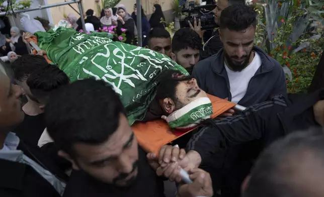 Mourners carry the body of Hamas local commander Mohammad Daraghmeh, 26, wrapped with a Hamas flag, during his funeral in the West Bank city of Tubas, Friday, April 12, 2024. Two Palestinians were killed early Friday in confrontations with Israeli forces in the Israeli-occupied West Bank, Palestinian medics and the Israeli military said. The Islamic militant group Hamas said one of those killed was a local commander. (AP Photo/Nasser Nasser)