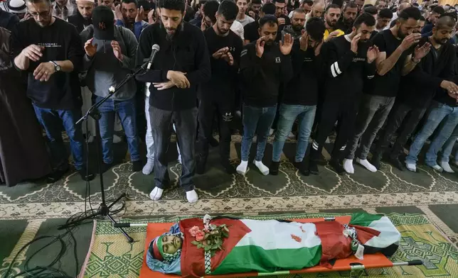 Palestinian men prayer near to the body of Yazan Shtayyeh,17, killed in an Israeli military raid, during his funeral in West Bank village of Salem, Near the Palestinian town of Nablus, Monday, April 15, 2024. (AP Photo/Majdi Mohammed)