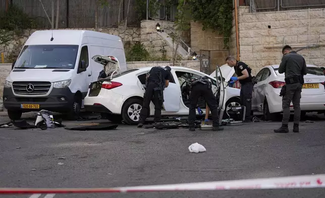 Israeli police investigate the scene of a suspected ramming attack that wounded three people on the eve of the Jewish holiday of Passover, in Jerusalem, Monday, April 22, 2024. Israeli police say a car slammed into pedestrians in Jerusalem on Monday, wounding three people lightly in an apparent attack. (AP Photo/Ohad Zwigenberg)