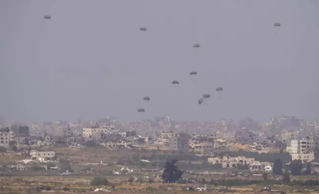 Parachutes drop supplies into the northern Gaza Strip, seen from southern Israel, Monday, April 15, 2024. (AP Photo/Ohad Zwigenberg)