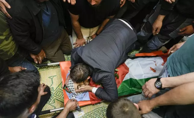 A Palestinian man kisses Yazan Shtayyeh,17, killed in an Israeli military raid, during his funeral in West Bank village of Salem, Near the Palestinian town of Nablus, Monday, April 15, 2024. (AP Photo/Majdi Mohammed)