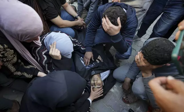 Palestinians mourn over a killed family member in the Al Aqsa hospital in Deir al Balah following an Israeli bombardment in the Maghazi refugee camp, central Gaza Strip, Tuesday, April 16, 2024. Several killed in a strike in Maghazi camp in Central Gaza on Tuesday. (AP Photo/Abdel Kareem Hana)
